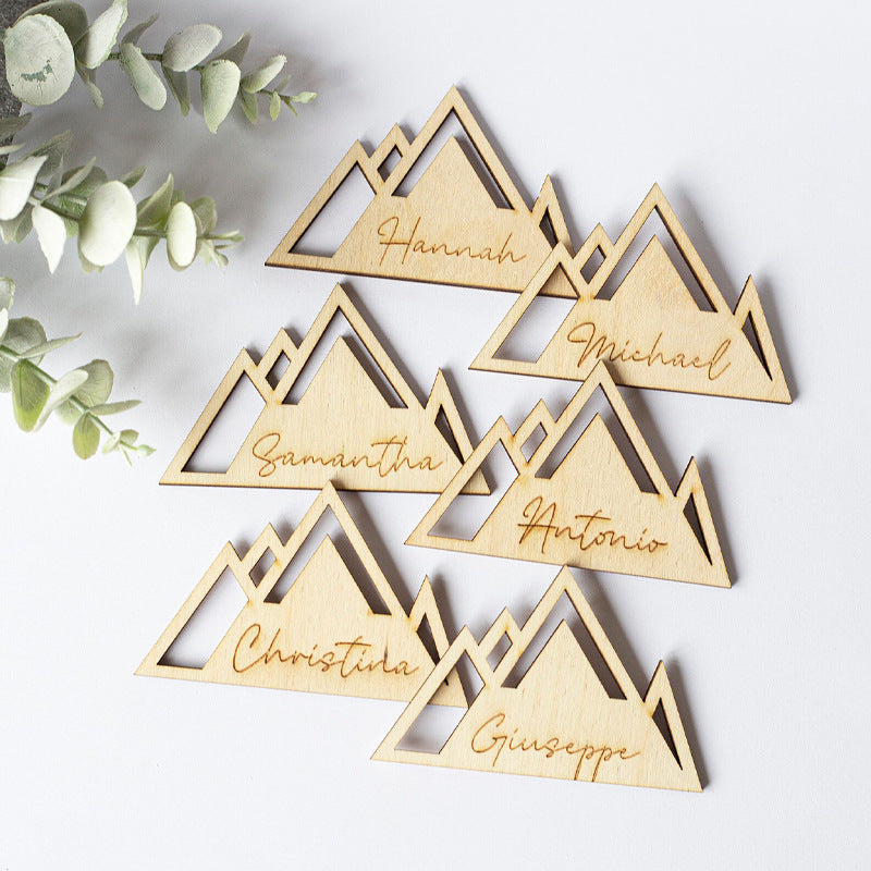 Wooden place cards with mountain design and names.