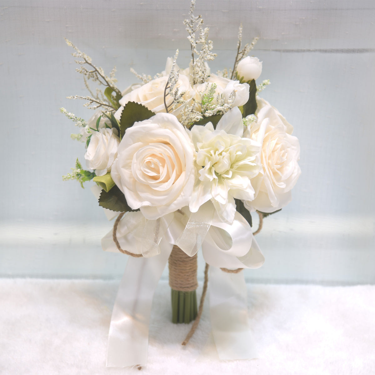 Cream-colored artificial wedding bouquet with lace and twine. 