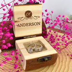 Personalized wooden ring box with initials and family name.