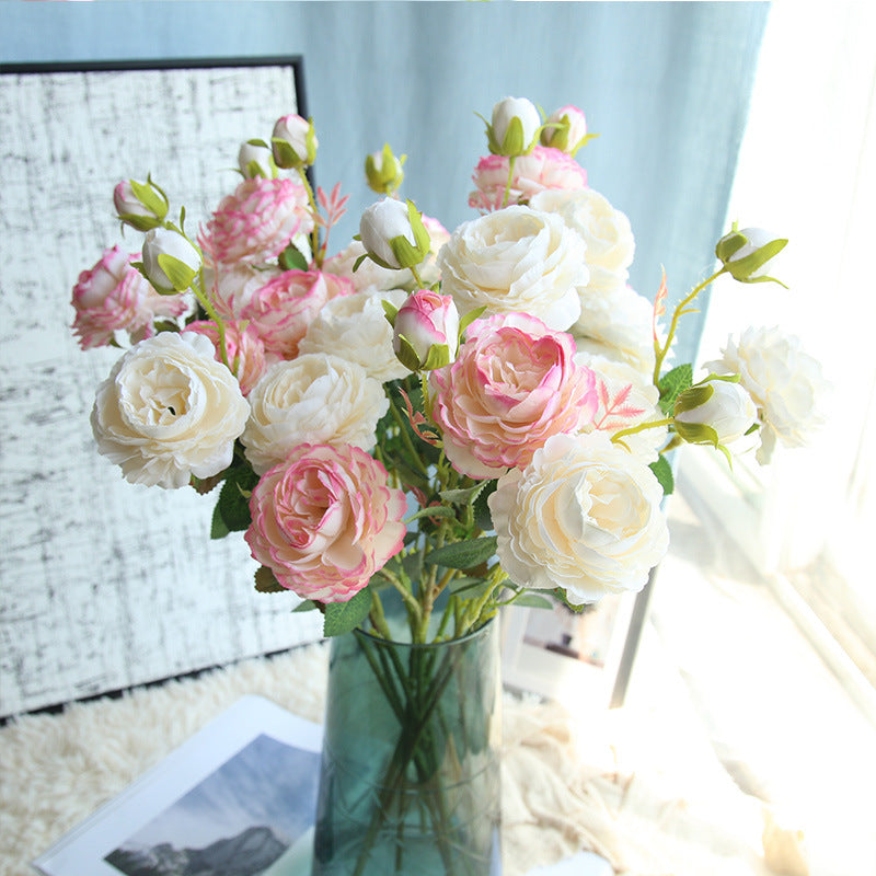  Bouquet of artificial peonies and roses in a clear vase. 