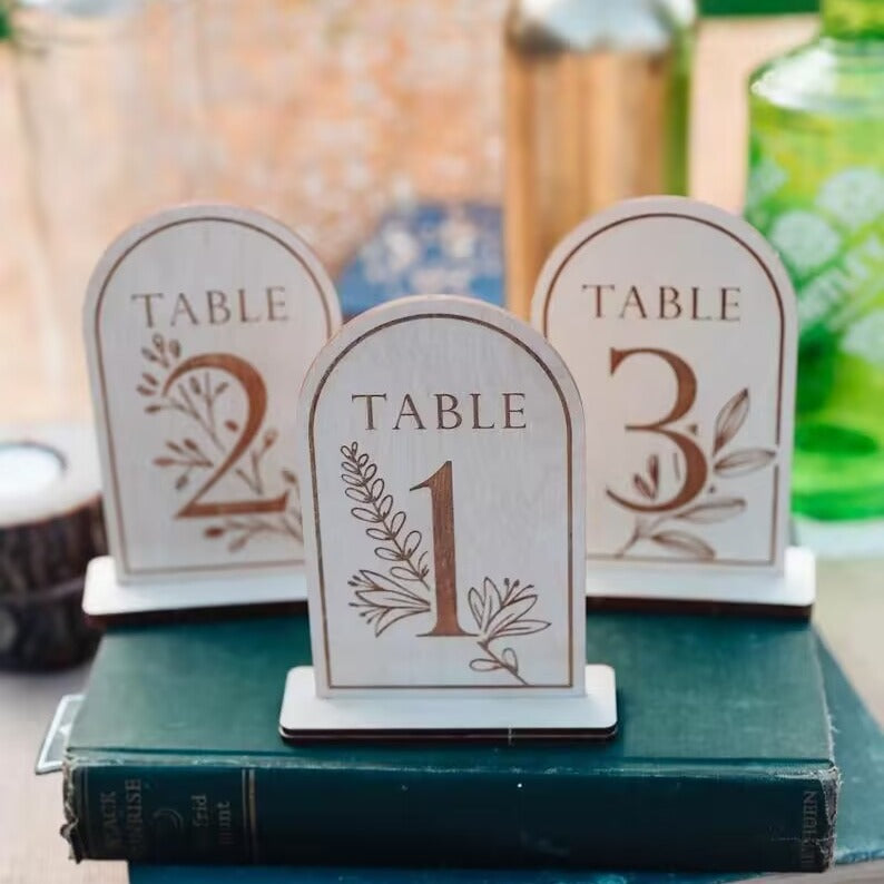 Carved wooden table markers for a wedding reception.